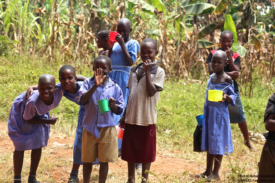 an image of Ugandan children waving with cups