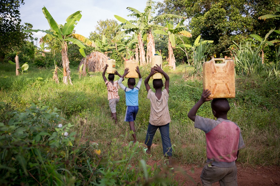 children walking with yellow jerry cans on their heads