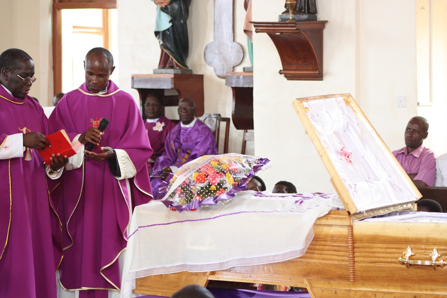 The priests give the final blessing over the late sister's grave