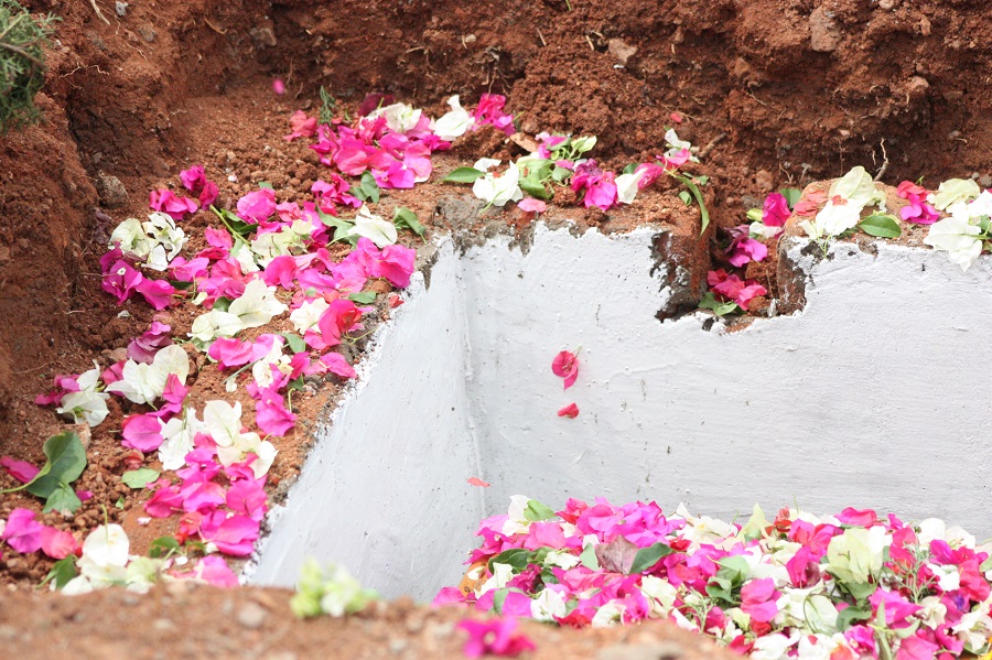 Flowers are dropped into sister's grave by every burial attendee